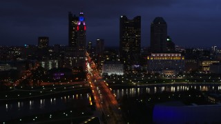 5.7K aerial stock footage of flying by the city's skyline across a bridge and river at twilight, Downtown Columbus, Ohio Aerial Stock Footage | DX0001_002786