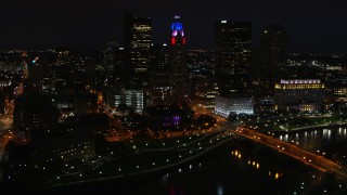 DX0001_002801 - 5.7K aerial stock footage of flying by LeVeque Tower and bridge spanning the river at night, Downtown Columbus, Ohio