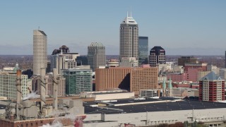 5.7K aerial stock footage of the city's skyline seen from factory smoke stacks in Downtown Indianapolis, Indiana Aerial Stock Footage | DX0001_002818