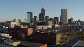 5.7K aerial stock footage descend near brick buildings with view of the skyline's towering skyscrapers in Downtown Indianapolis, Indiana Aerial Stock Footage | DX0001_002905