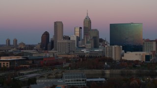 5.7K aerial stock footage of descending near hotel and city's skyline at sunset, Downtown Indianapolis, Indiana Aerial Stock Footage | DX0001_002943