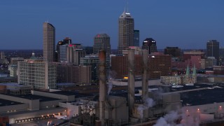 5.7K aerial stock footage flyby smoke stacks for view of city skyline at twilight in Downtown Indianapolis, Indiana Aerial Stock Footage | DX0001_002960