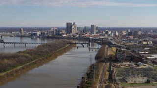 5.7K aerial stock footage of the city's skyline seen while flying by the river in Downtown Louisville, Kentucky Aerial Stock Footage | DX0001_002999