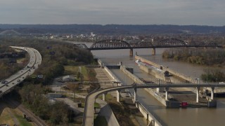 5.7K aerial stock footage flying by railroad bridge near locks and a dam on the Ohio River in Louisville, Kentucky Aerial Stock Footage | DX0001_003016