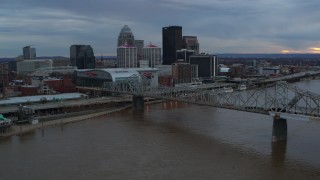 DX0001_003070 - 5.7K aerial stock footage of the arena and skyline, seen while flying by bridge and Ohio River at sunset, Downtown Louisville, Kentucky