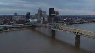 5.7K aerial stock footage reverse view of bridge spanning river and city skyline at sunset, Downtown Louisville, Kentucky Aerial Stock Footage | DX0001_003075