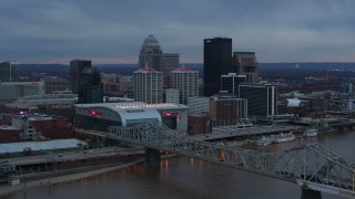 DX0001_003085 - 5.7K aerial stock footage of the arena and city skyline at sunset, seen from near the bridge, Downtown Louisville, Kentucky