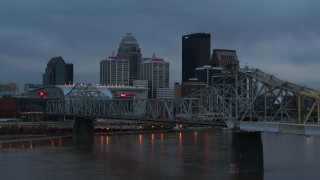 DX0001_003090 - 5.7K aerial stock footage flyby bridge over the river at sunset toward arena, skyline in background, Downtown Louisville, Kentucky