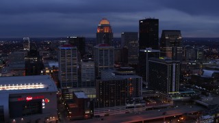 DX0001_003099 - 5.7K aerial stock footage of approaching the skyline lit up at twilight, Downtown Louisville, Kentucky