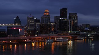 DX0001_003104 - 5.7K aerial stock footage stationary view of the skyline lit up at twilight, seen from Ohio River, Downtown Louisville, Kentucky