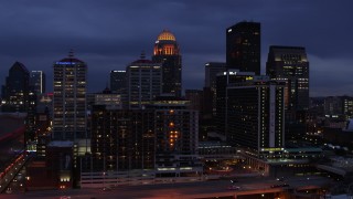 DX0001_003105 - 5.7K aerial stock footage fly over Ohio River toward the hotel and skyline lit up at twilight, Downtown Louisville, Kentucky