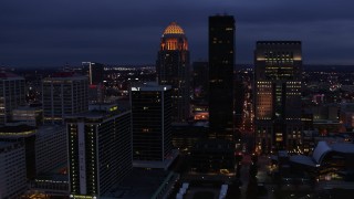 5.7K aerial stock footage reverse view of a tall skyscraper and skyline lit up at twilight, Downtown Louisville, Kentucky Aerial Stock Footage | DX0001_003107