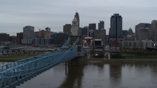 DX0001_003134 - 5.7K aerial stock footage ascend by Roebling Bridge to approach the city's skyline, Downtown Cincinnati, Ohio