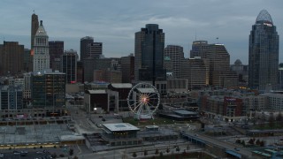 5.7K aerial stock footage flyby the Ferris wheel and away from the city skyline at sunset, Downtown Cincinnati, Ohio Aerial Stock Footage | DX0001_003152