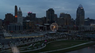 5.7K aerial stock footage approach the city skyline and Ferris wheel at sunset from Ohio River, Downtown Cincinnati, Ohio Aerial Stock Footage | DX0001_003160