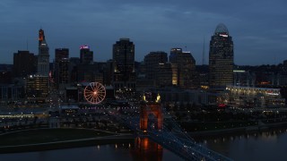 5.7K aerial stock footage flyby city skyline and bridge lit for twilight, seen from Ohio River, Downtown Cincinnati, Ohio Aerial Stock Footage | DX0001_003166