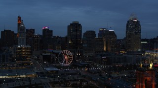 5.7K aerial stock footage approach city skyline and Ferris wheel lit up at twilight, seen from Ohio River, Downtown Cincinnati, Ohio Aerial Stock Footage | DX0001_003167