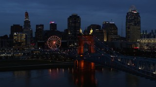 5.7K aerial stock footage flyby Roebling Bridge lit up at twilight, and away from city skyline, Downtown Cincinnati, Ohio Aerial Stock Footage | DX0001_003174