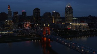 5.7K aerial stock footage fly away from city skyline lit up at twilight, reveal the bridge and river, Downtown Cincinnati, Ohio Aerial Stock Footage | DX0001_003177