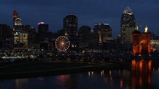 5.7K aerial stock footage fly away from skyscraper and Ferris wheel at twilight, reveal the river and bridge, Downtown Cincinnati, Ohio Aerial Stock Footage | DX0001_003183