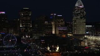 5.7K aerial stock footage of flying by tall skyscrapers and Ferris wheel at night in Downtown Cincinnati, Ohio Aerial Stock Footage | DX0001_003192