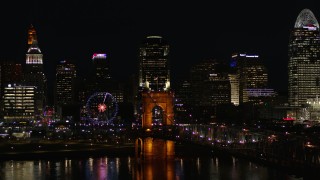 DX0001_003201 - 5.7K aerial stock footage descend by Roebling Bridge at night with city skyline in background, Downtown Cincinnati, Ohio