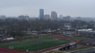 DX0001_003209 - 5.7K aerial stock footage of the city skyline seen while descending by football field, Downtown Lexington, Kentucky