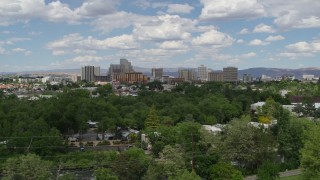 DX0001_004_044 - 5.7K aerial stock footage of ascending near trees with a view of hotels and casinos of the city's skyline in Reno, Nevada