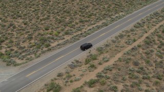 DX0001_007_020 - 5.7K aerial stock footage approach a black SUV parked on a desert road in Carson City, Nevada