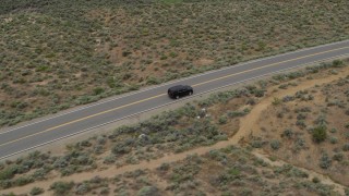 DX0001_007_021 - 5.7K aerial stock footage track a black SUV driving on a desert road in Carson City, Nevada