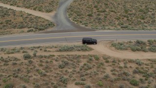 DX0001_007_023 - 5.7K aerial stock footage track a black SUV as it turns and drives in the opposite direction in Carson City, Nevada