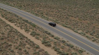 DX0001_007_024 - 5.7K aerial stock footage track a black SUV as travels on a desert road in Carson City, Nevada