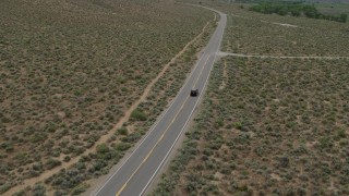 DX0001_007_025 - 5.7K aerial stock footage of a black SUV traveling on a desert road in Carson City, Nevada