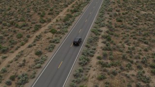 DX0001_007_026 - 5.7K aerial stock footage of a black SUV pulling onto a desert road in Carson City, Nevada