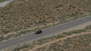 DX0001_007_029 - 5.7K aerial stock footage of a black SUV driving on a desert road in Carson City, Nevada