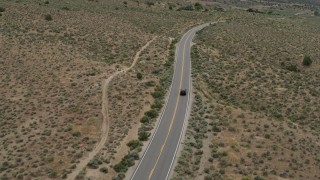 DX0001_007_030 - 5.7K aerial stock footage of a black SUV driving on a lonely desert road in Carson City, Nevada