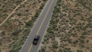 DX0001_007_031 - 5.7K aerial stock footage of revealing a black truck driving on a desert road in Carson City, Nevada