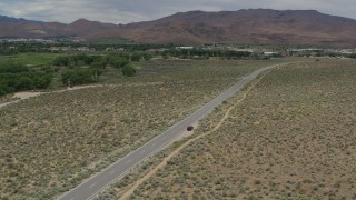 DX0001_007_034 - 5.7K aerial stock footage approach a black SUV driving to the side of the road in Carson City, Nevada