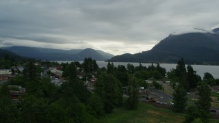 DX0001_008_004 - 5.7K aerial stock footage of bridges spanning creek, and mountains across the Columbia River at sunrise, Stevenson, Washington