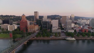 4K aerial stock footage flying by office building and the Hawthorne Bridge at sunrise, Downtown Portland, Oregon Aerial Stock Footage | DX0001_010_003