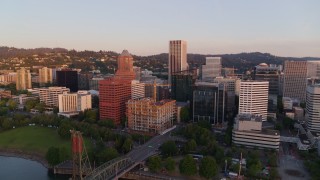 4K aerial stock footage approaching downtown buildings, passing the Hawthorne Bridge at sunrise, Downtown Portland, Oregon Aerial Stock Footage | DX0001_010_012