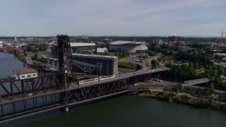 DX0001_012_009 - 5.7K aerial stock footage of MAX Light Rail on Steel Bridge near arenas, Northeast Portland, Oregon