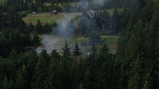 5.7K aerial stock footage orbit a fire near rural homes in Hood River, Oregon Aerial Stock Footage | DX0001_015_027