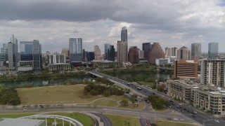 5.7K aerial stock footage of a reverse view of First Street Bridge, Lady Bird Lake and the city skyline, Downtown Austin, Texas Aerial Stock Footage | DX0002_102_009