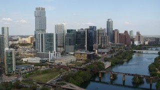 5.7K aerial stock footage tall skyscrapers seen while flying by bridges over Lady Bird Lake, Downtown Austin, Texas Aerial Stock Footage | DX0002_104_006