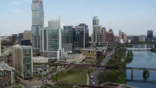 5.7K aerial stock footage flying by tall skyscrapers, bridges over Lady Bird Lake before descent, Downtown Austin, Texas Aerial Stock Footage | DX0002_104_010