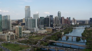 5.7K aerial stock footage passing towering skyscrapers by bridges over Lady Bird Lake, Downtown Austin, Texas Aerial Stock Footage | DX0002_104_015