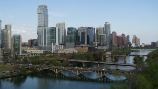 5.7K aerial stock footage descend bridges over Lady Bird Lake with view of skyscrapers, Downtown Austin, Texas Aerial Stock Footage | DX0002_104_016