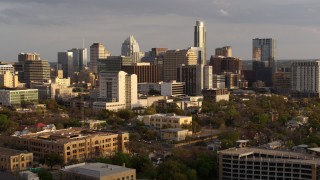 DX0002_104_043 - 5.7K aerial stock footage fly away from a courthouse and office buildings near skyscrapers at sunset in Downtown Austin, Texas, and descend