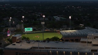 DX0002_105_037 - 5.7K aerial stock footage of ascending by baseball stadium at the University of Texas at twilight, Austin, Texas